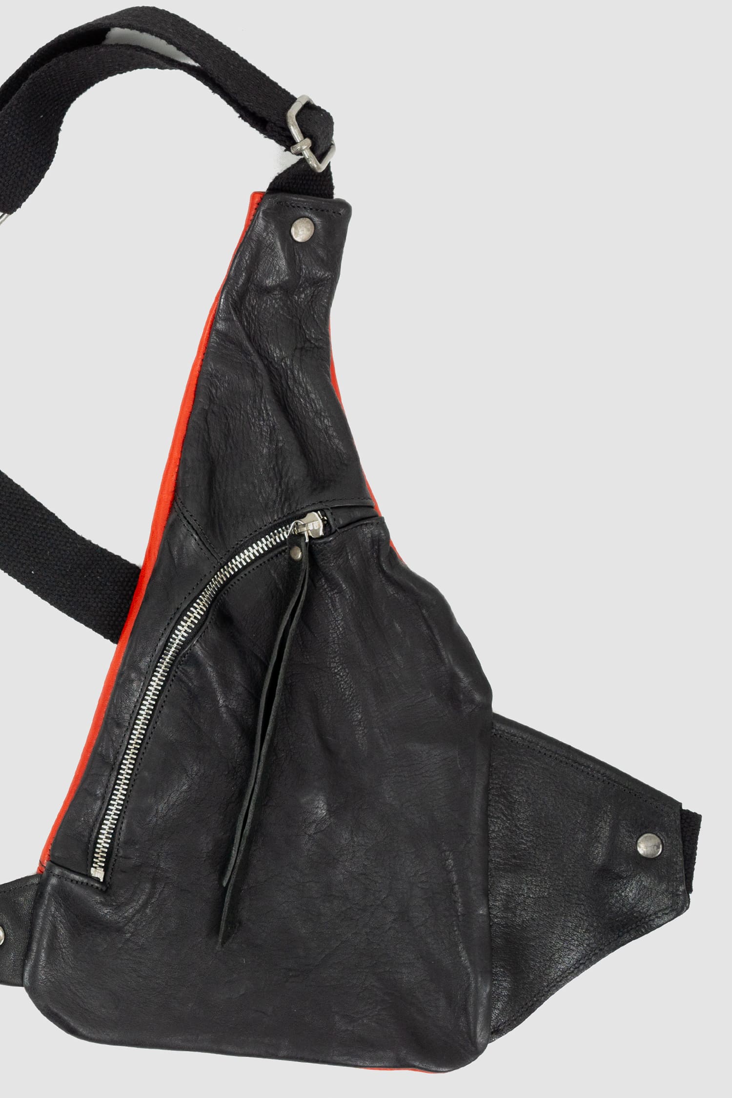0.Hide - right detail view of vegetable tanned black and red horsehide leather cargo vest from the permanent collection with two types of horse leather shoulder panels, adjustable cotton straps and zippered pockets.