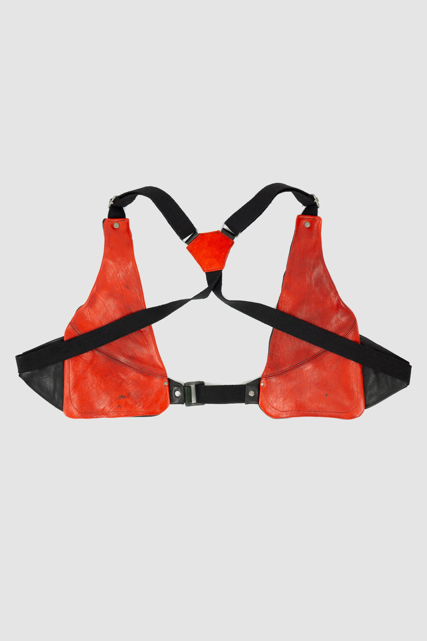 0.Hide - back solo view of vegetable tanned black and red horsehide leather cargo vest from the permanent collection with two types of horse leather shoulder panels, adjustable cotton straps and zippered pockets.
