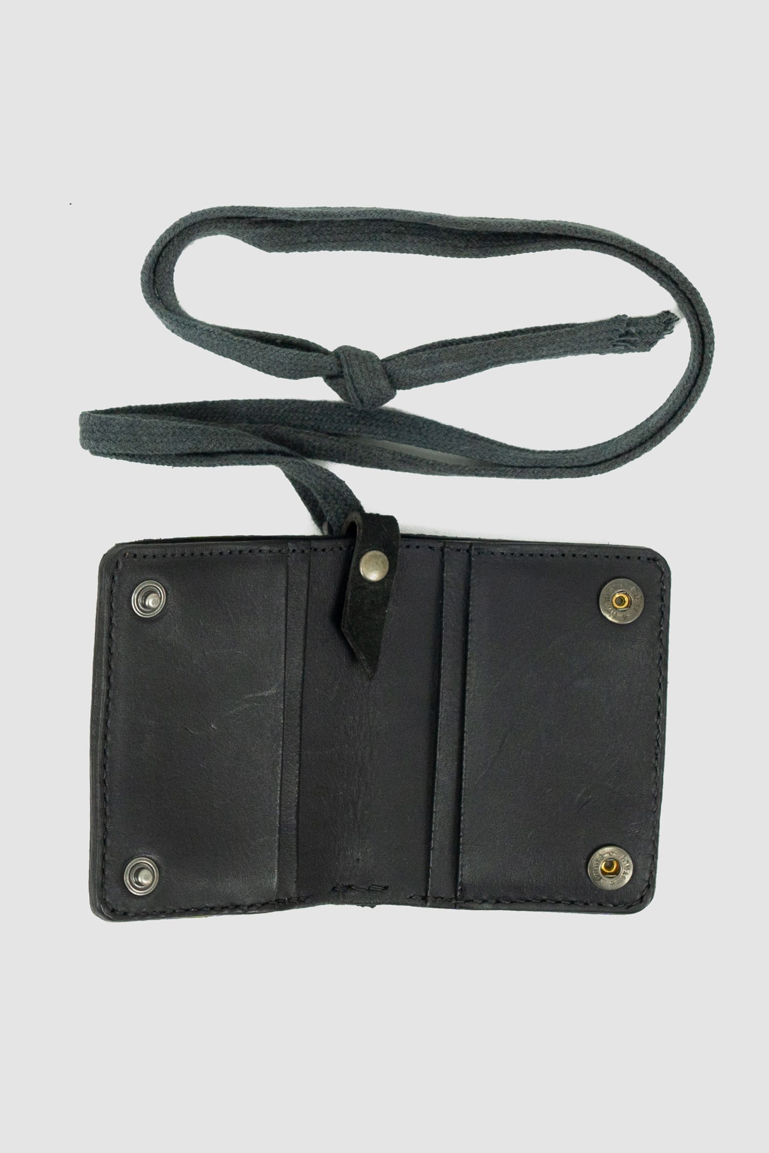 0.Hide - inner view of vegetable tanned black cordovan shell leather snap holder wallet from the permanent collection with 4 card slots, branded metal details and cotton straps.