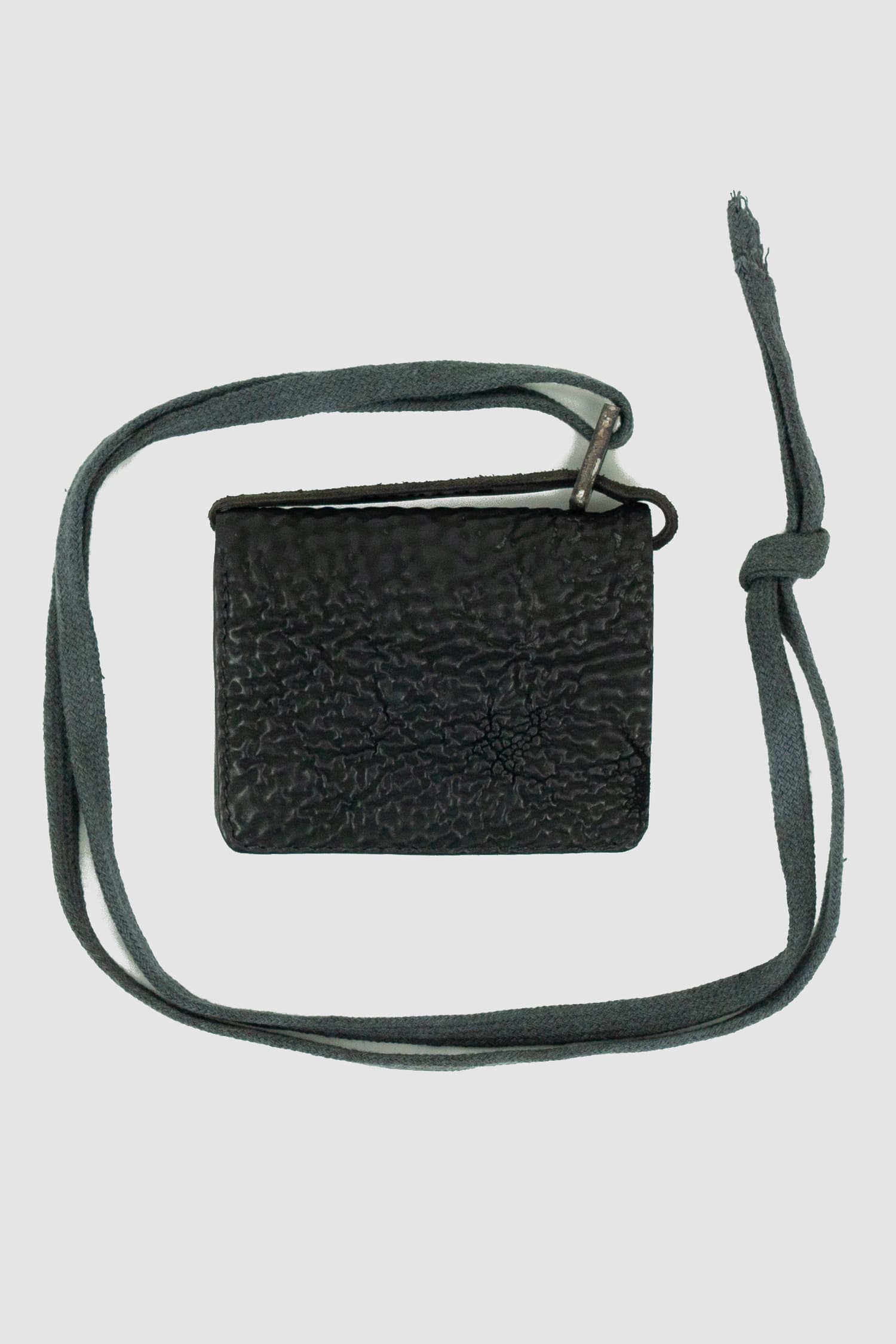 0.Hide - back solo view of vegetable tanned black cordovan shell leather snap holder wallet from the permanent collection with 4 card slots, branded metal details and cotton straps.