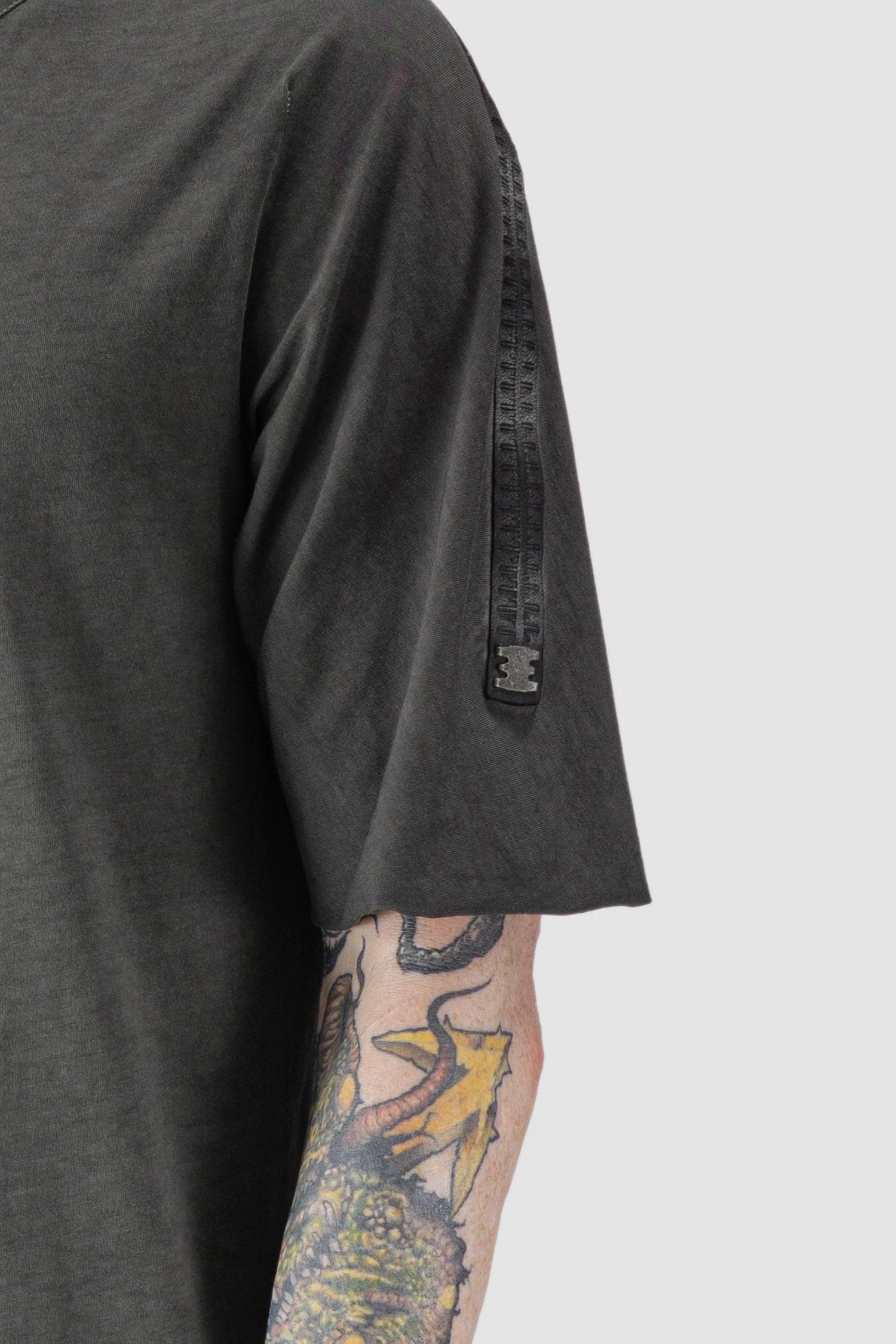 69 by Isaac Sellam - model arm detail view of Grey Object Dyed Leather Spine Short Sleeve Tee