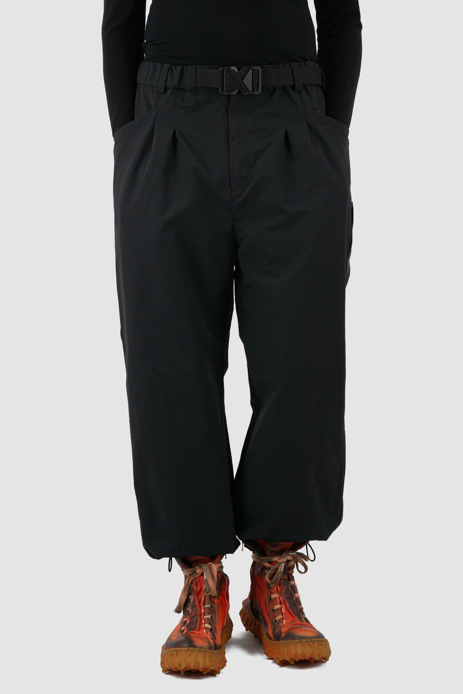 First Aid to the Injured - relax view of black belted utility pants with side straps for men from the FW24 collection feature an integrated snap belt and an elasticated parachute hem fastening.