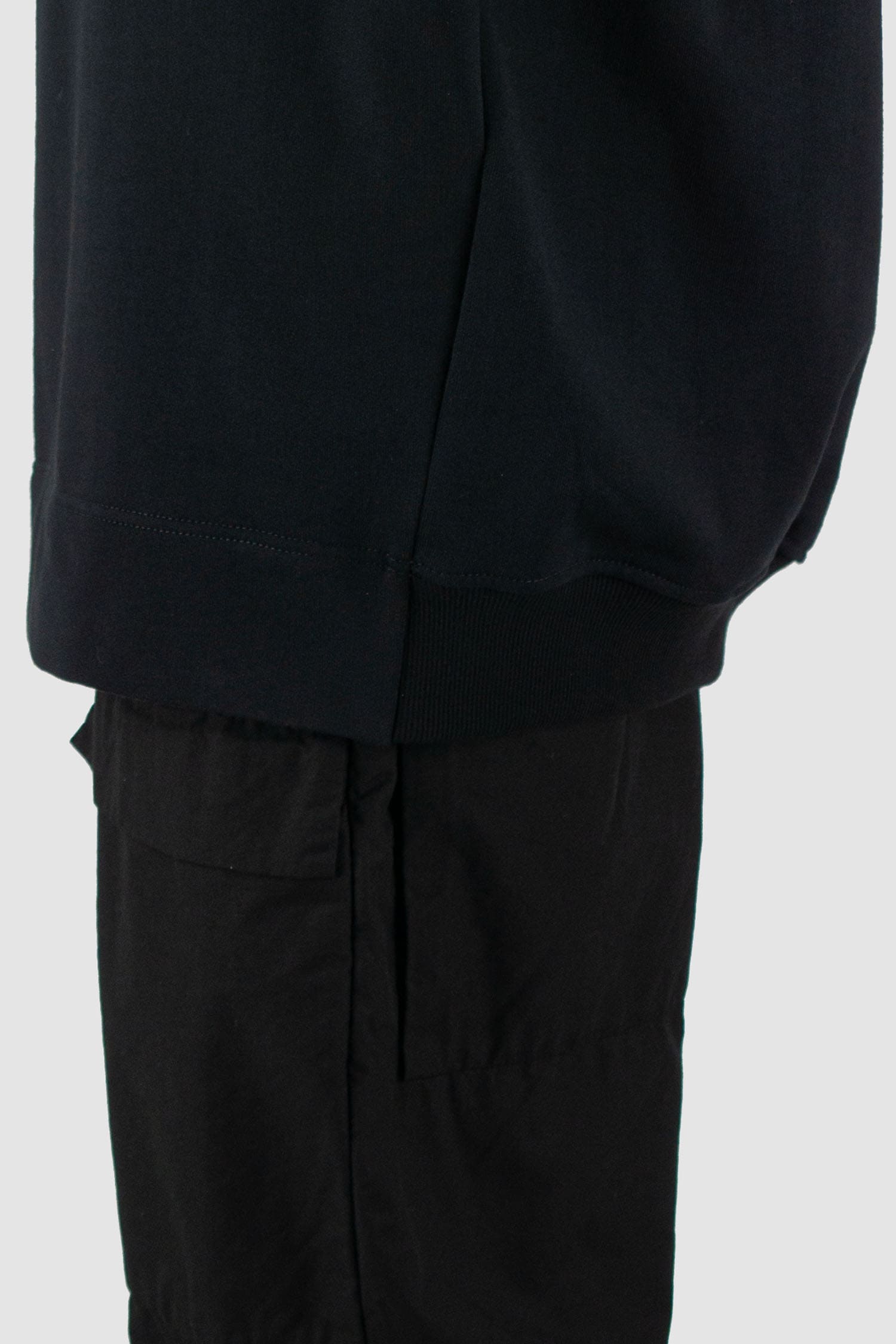 Nomen Nescio - hem view of black cotton raglan sweater with wool rib detail, spacious relaxed fit.
