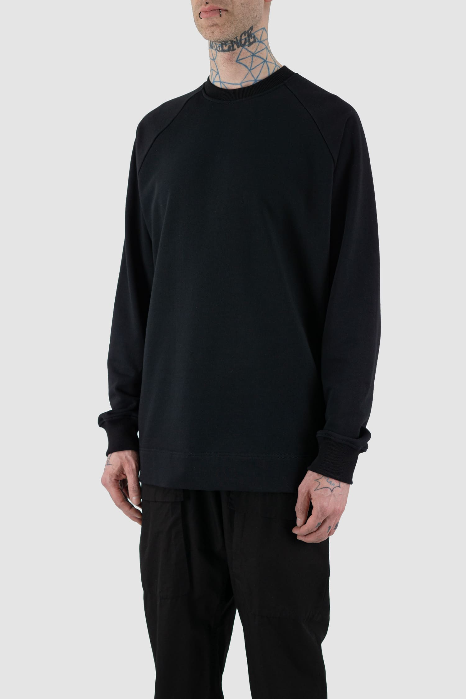 Nomen Nescio - side view of black cotton raglan sweater.