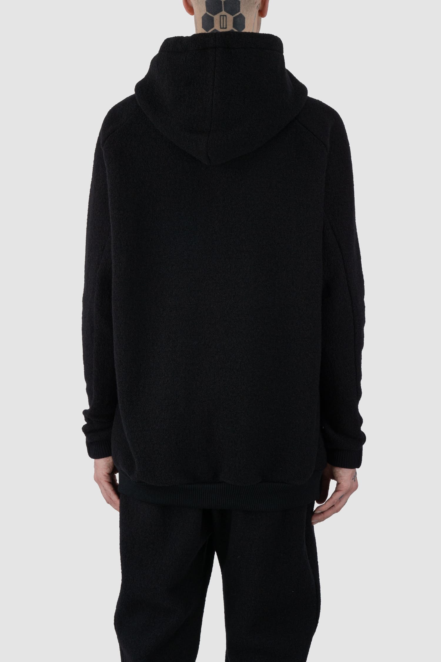Nomen Nescio - back view of black recycled wool hoodie 518 for men from the FW24 collection offers a roomy fit with a large hood and wool rib details on the hem and cuffs.
