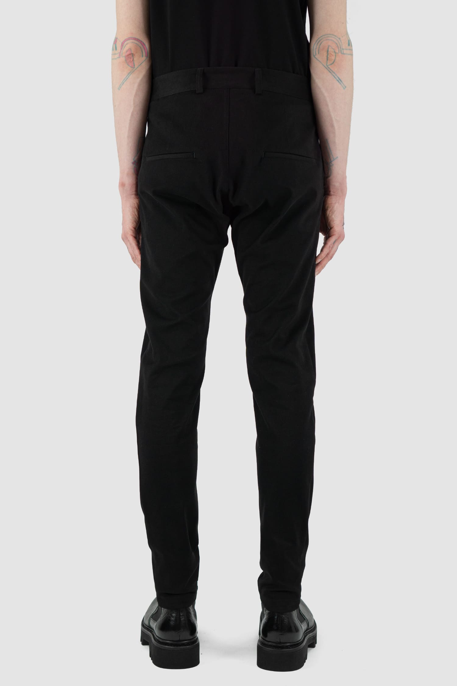 Nomen Nescio - back view of black cotton blend slim trousers with slanted front pockets, zip-fly fastening.