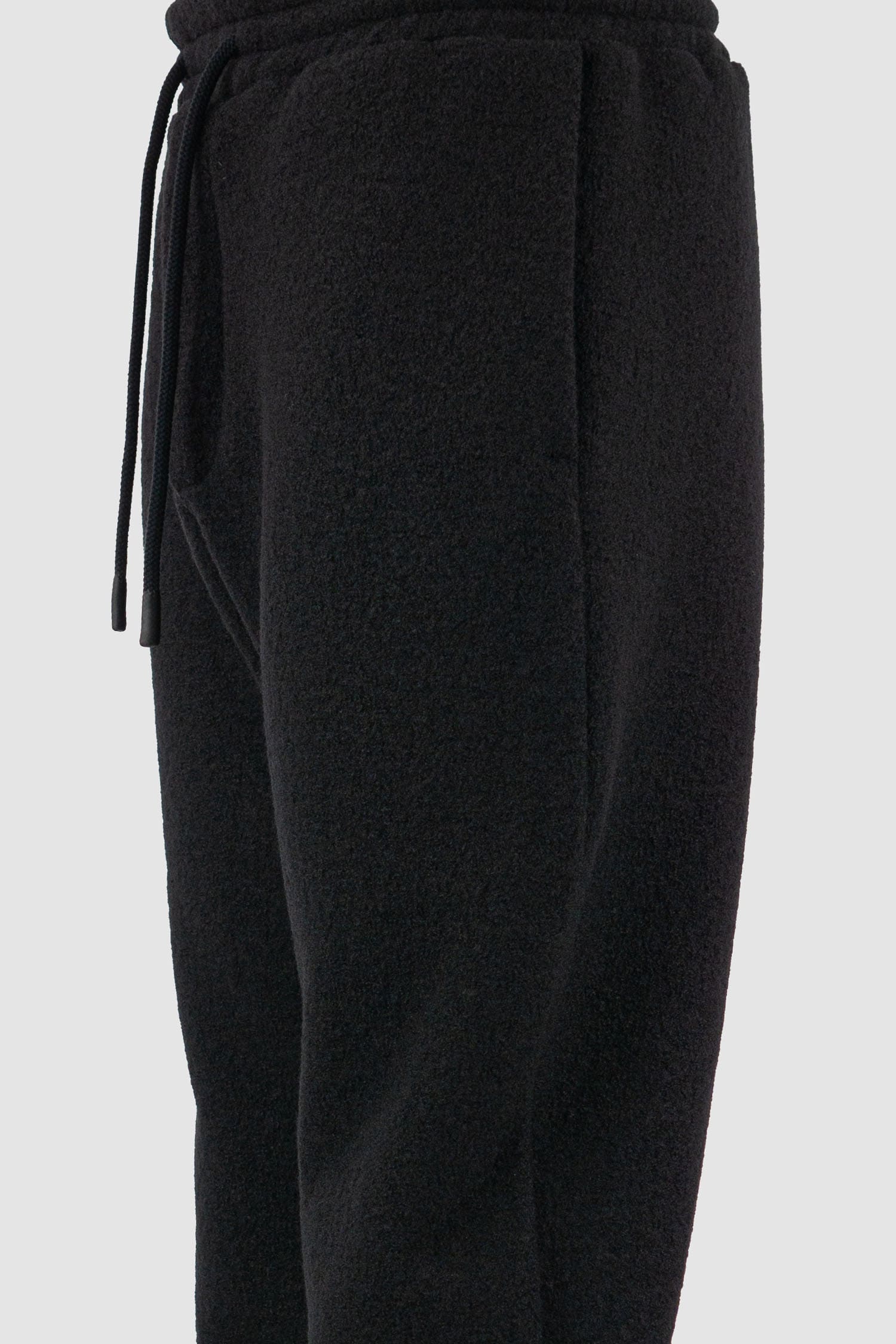 Nomen Nescio - detail view of black woolen sweatpants with elastic waistband, recycled wool, for men.
