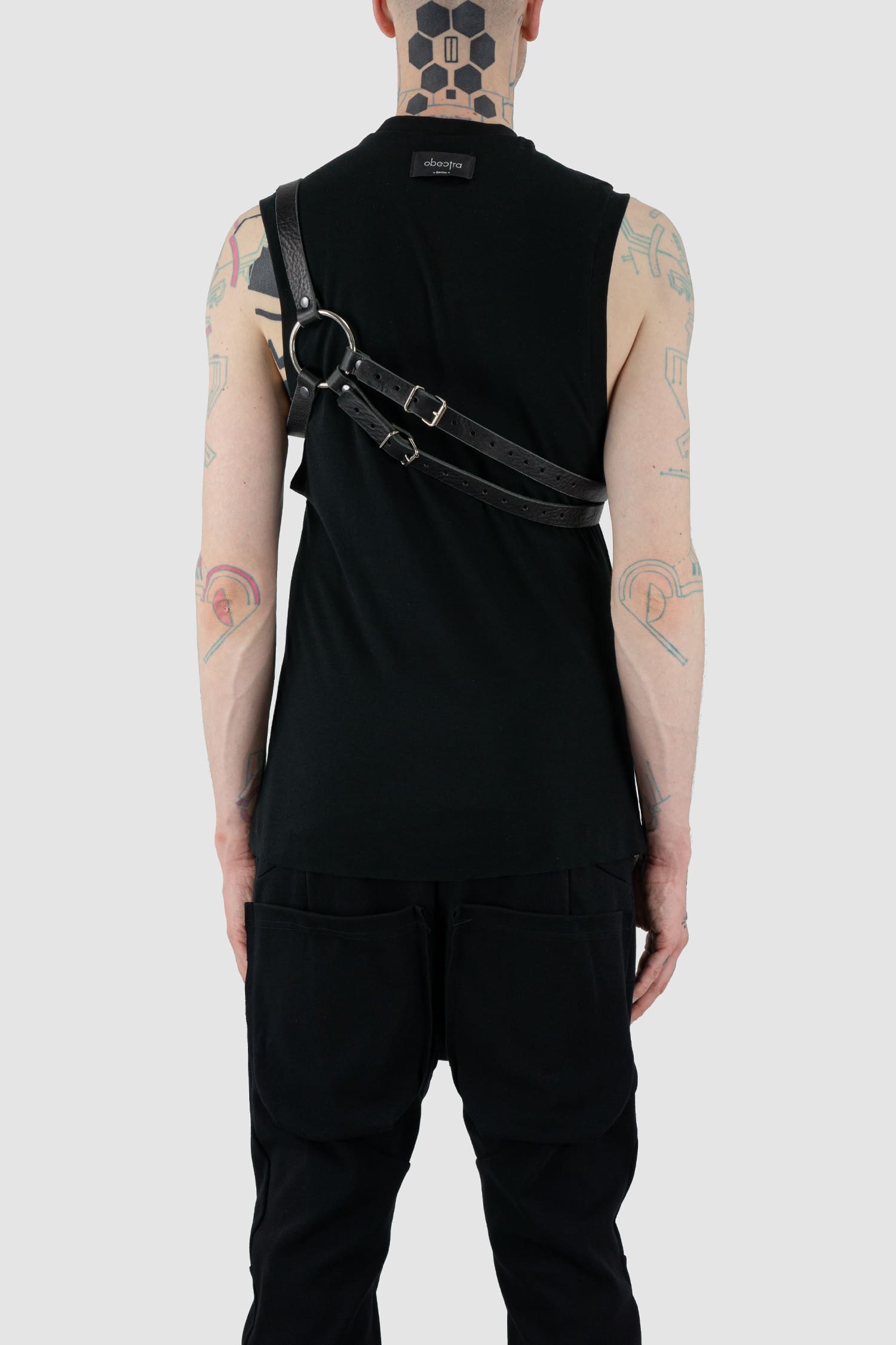 Obectra Studio - Model back 2 view of black double strap leather harness with adjustable buckles, large metal ring, Permanent Collection.