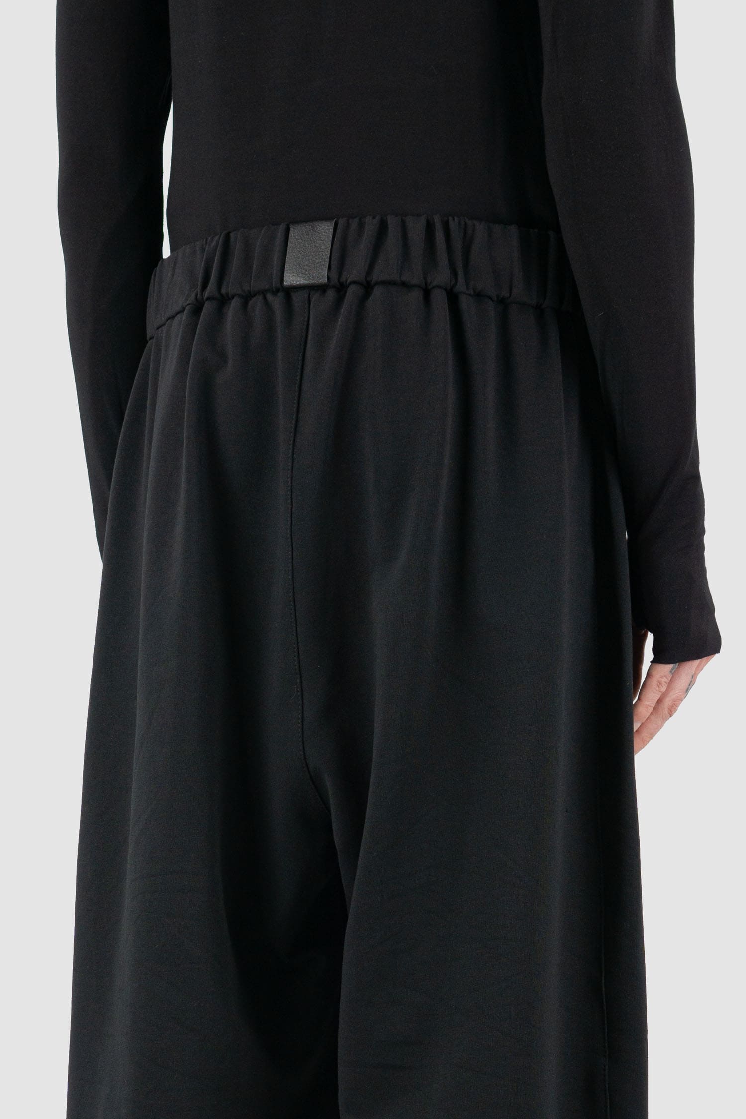 UY Studio - back detail view of black cotton wide leg Gangster sweatpants with elastic waistband, clean edge hem, Permanent Collection.