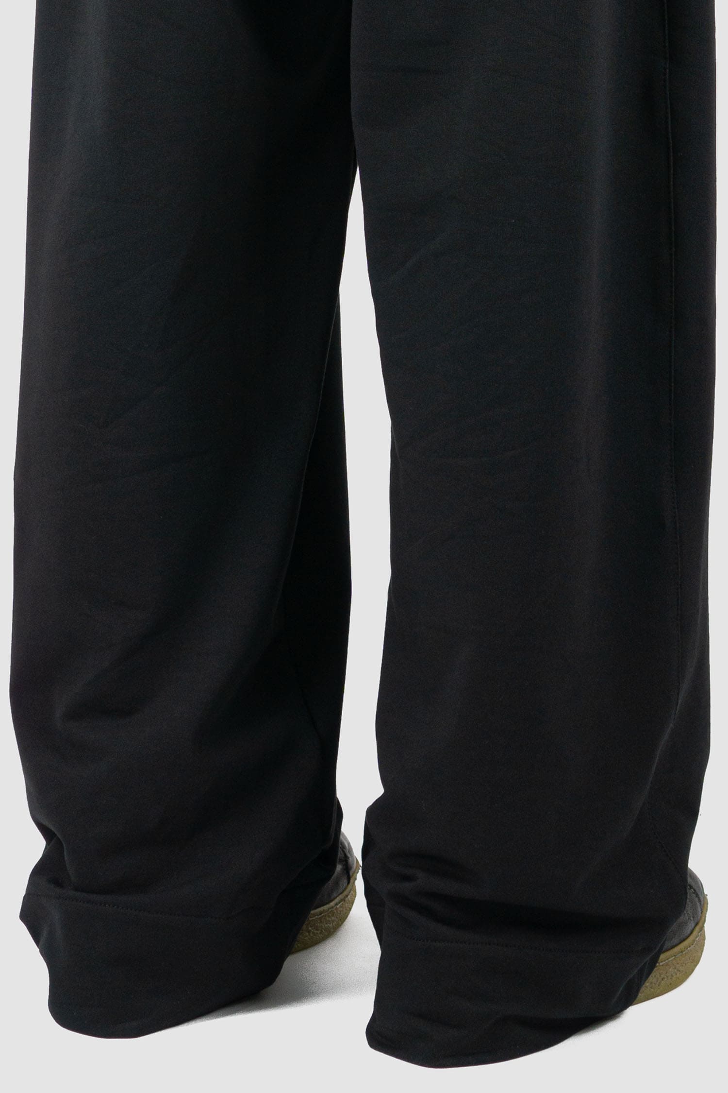 UY Studio - back hem view of black cotton wide leg Gangster sweatpants with elastic waistband, clean edge hem, Permanent Collection.