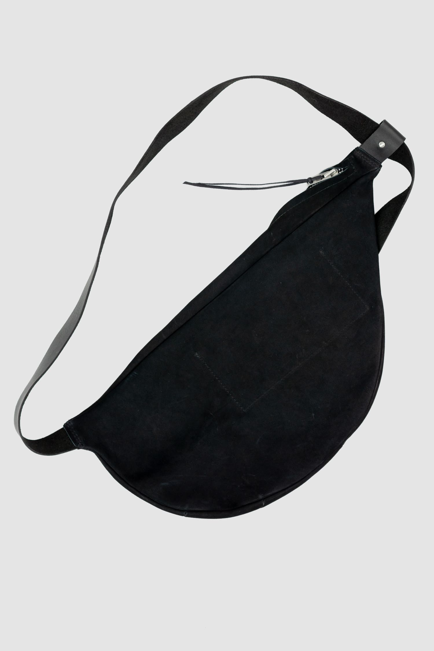 Werkschwarz - Back view of black big nubuck leather cross body bag Werk 12N is the perfect versatile fanny pack from the Permanent collection. It features a silky sanded finish, metal rivets, and a spiral zip closure, combining style with functionality.