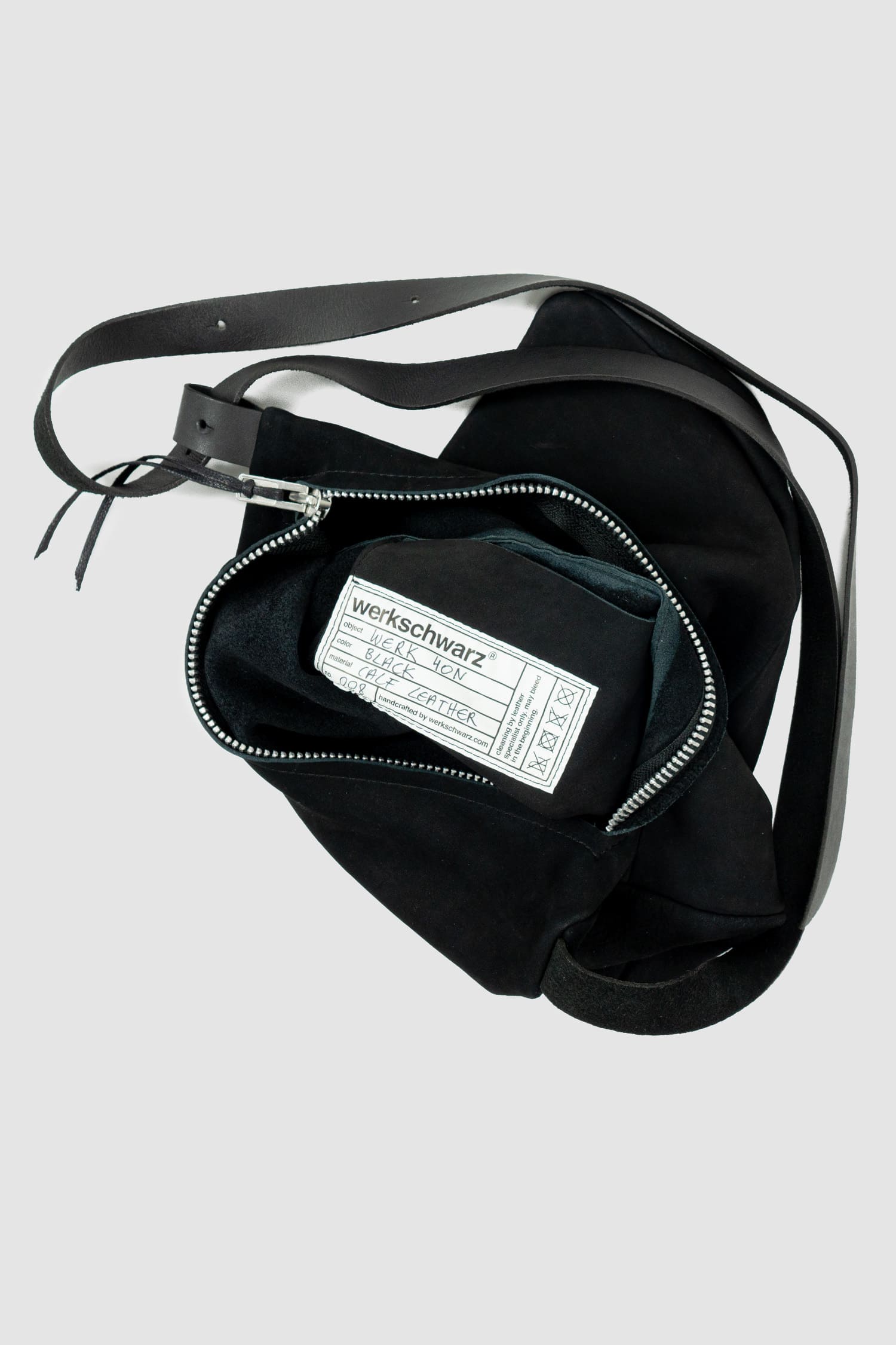 Werkschwarz - Detail view of black nubuck leather one-shoulder pack bag Werk 40N, the best all-rounder for everyday use from the Permanent collection. It has a silky waxed surface, a large YKK spiral zipper and an inside pocket.