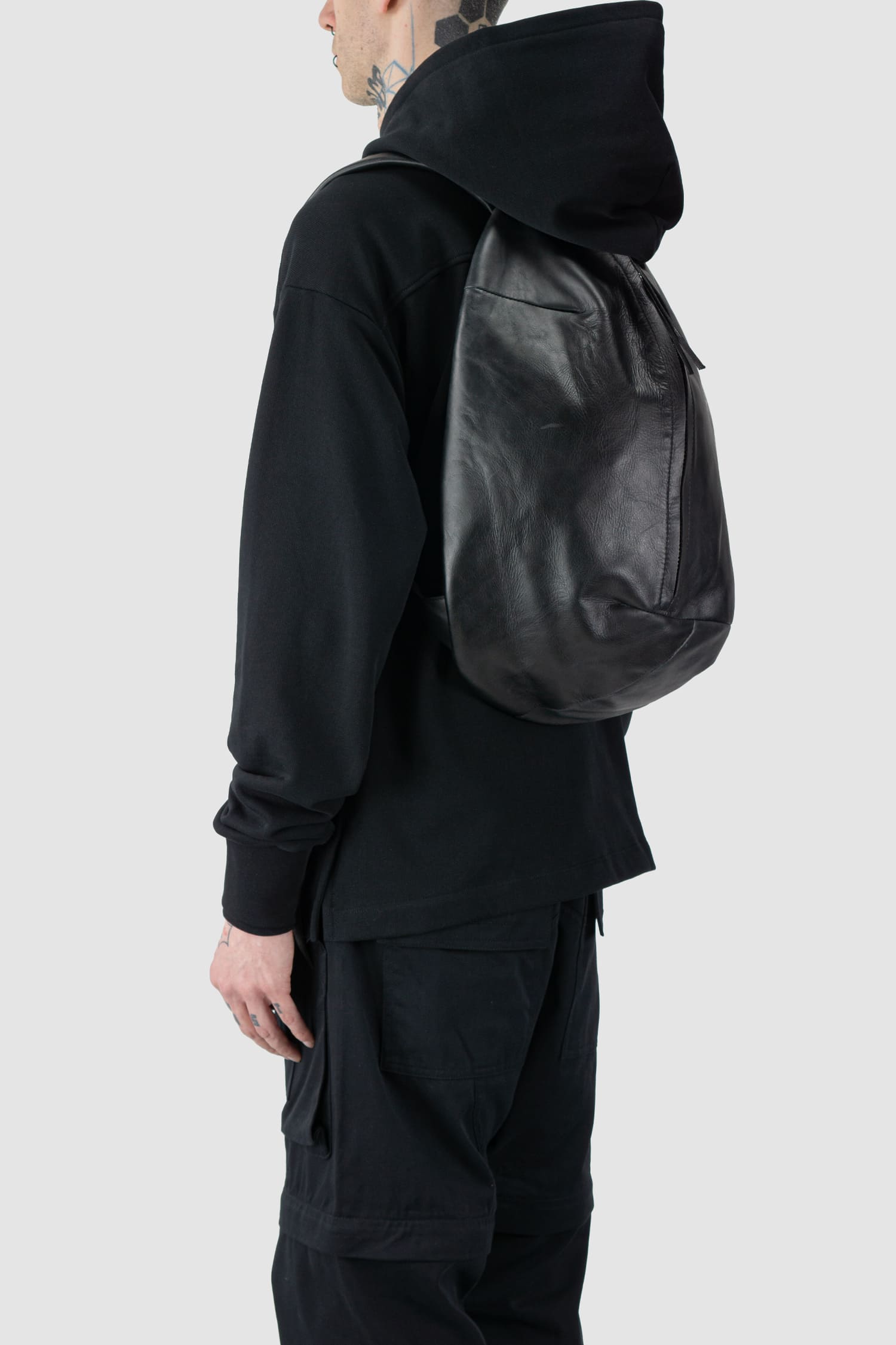 Werkschwarz - side person view of the black Polished Cow Leather Backpack Werk 1P.