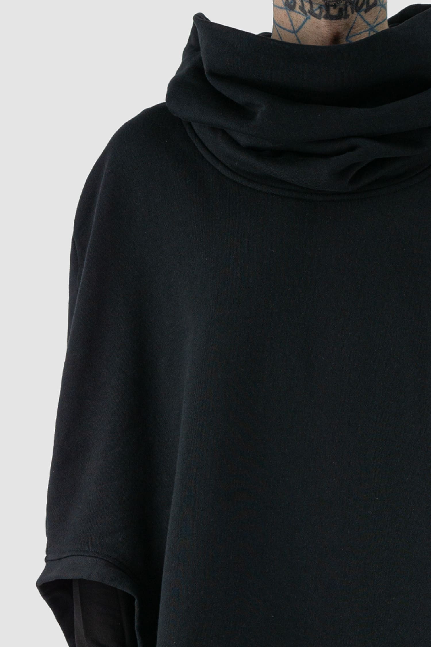 XConcept - Front detail view of black overlapping shoulder high neck top for men with asymmetrical cut, stand-up collar, thick cotton, FW24 Collection.