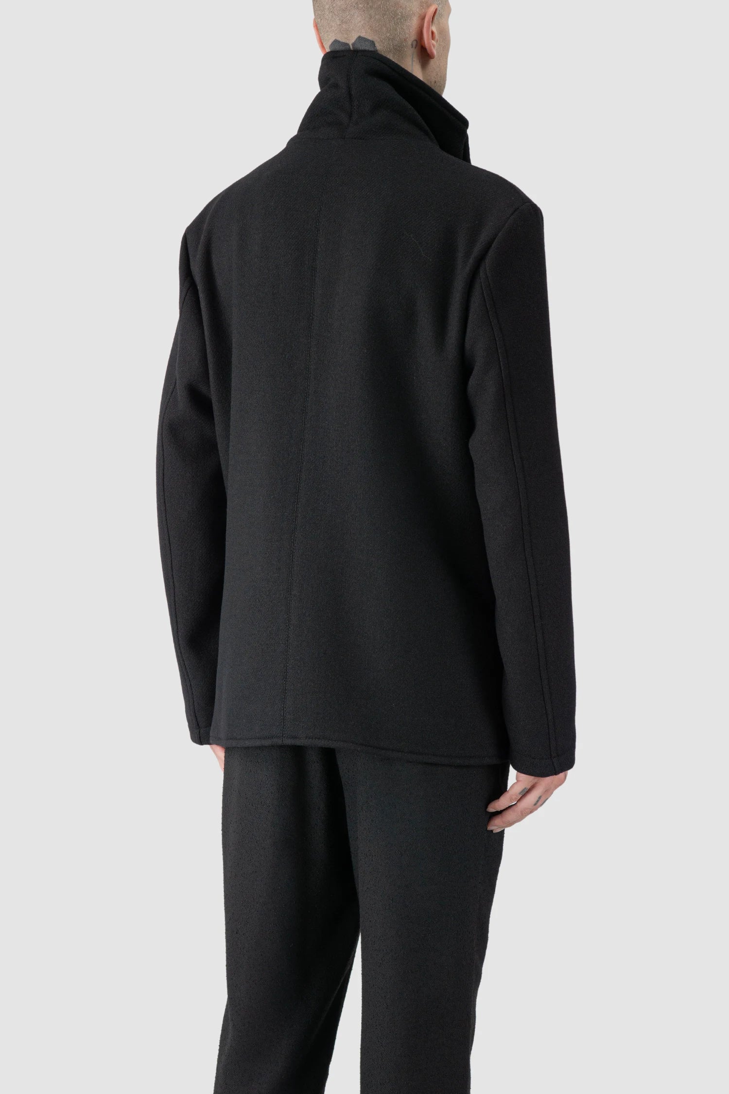La Haine Inside Us - model back side view of men’s FW25 Black Asymmetric Draped High Collar Wool Jacket