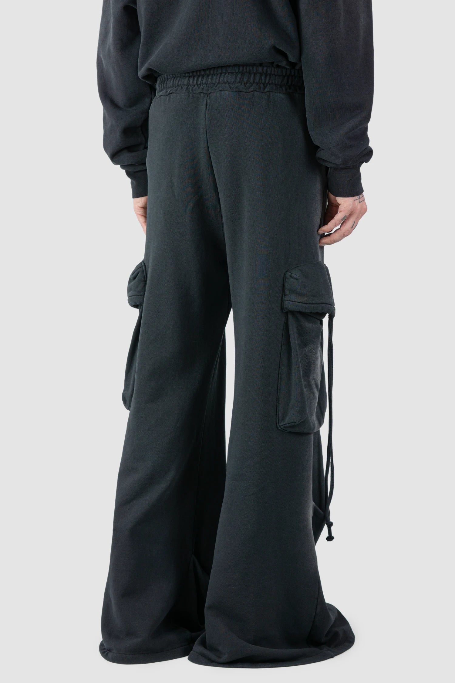 La Haine Inside Us - model back side view of men’s FW25 Grey Sprayed Cotton Wide Leg Cargo Jogger Pants