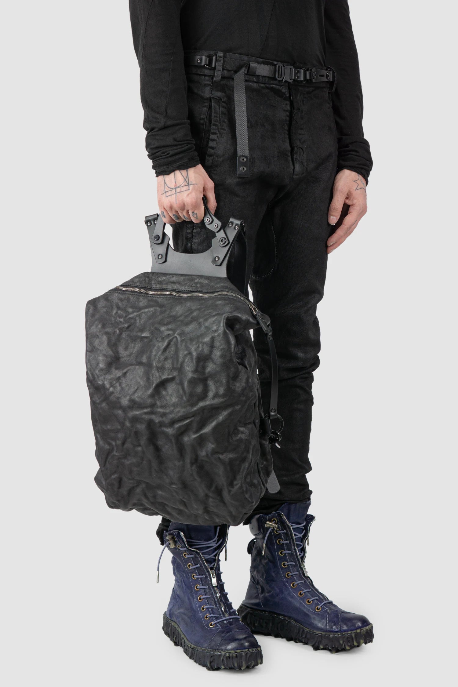 TEO NG - NIKS - model hand carry view of men’s Black Crinkled Leather Backpack