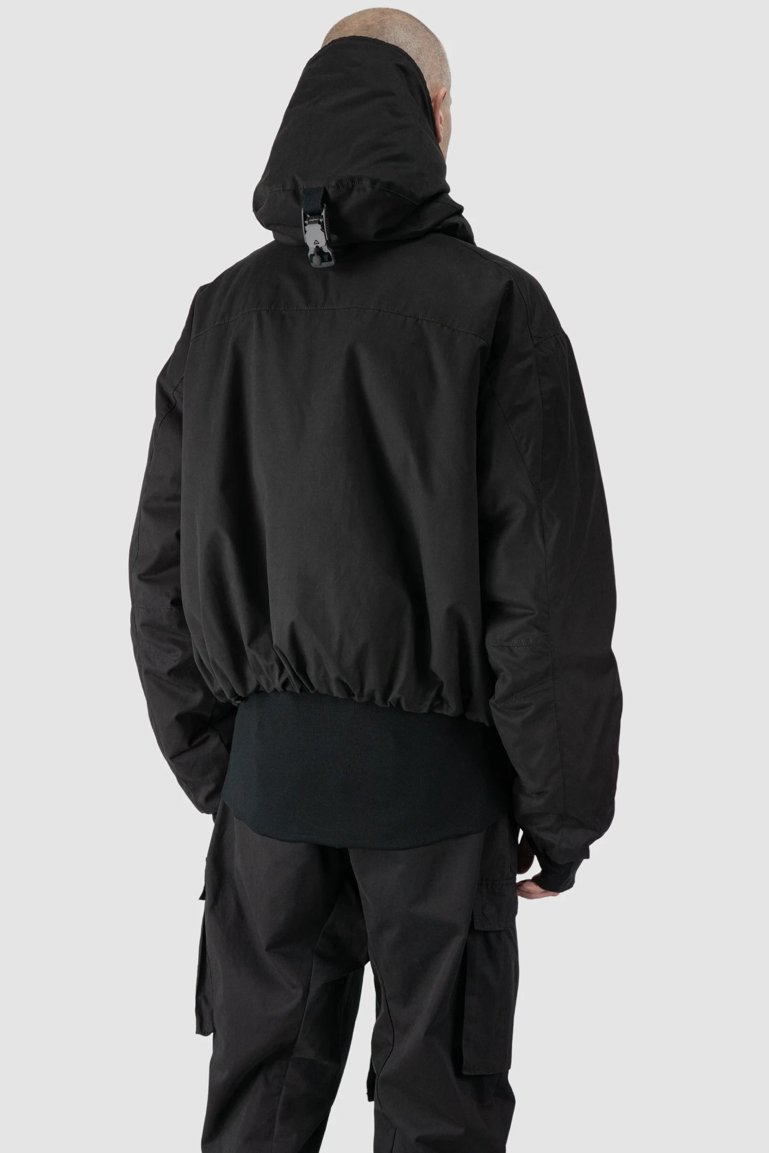Thom Krom - model back side view of men’s Black Padded Short Jacket with Magnetic Buckle Hoody M-J-74