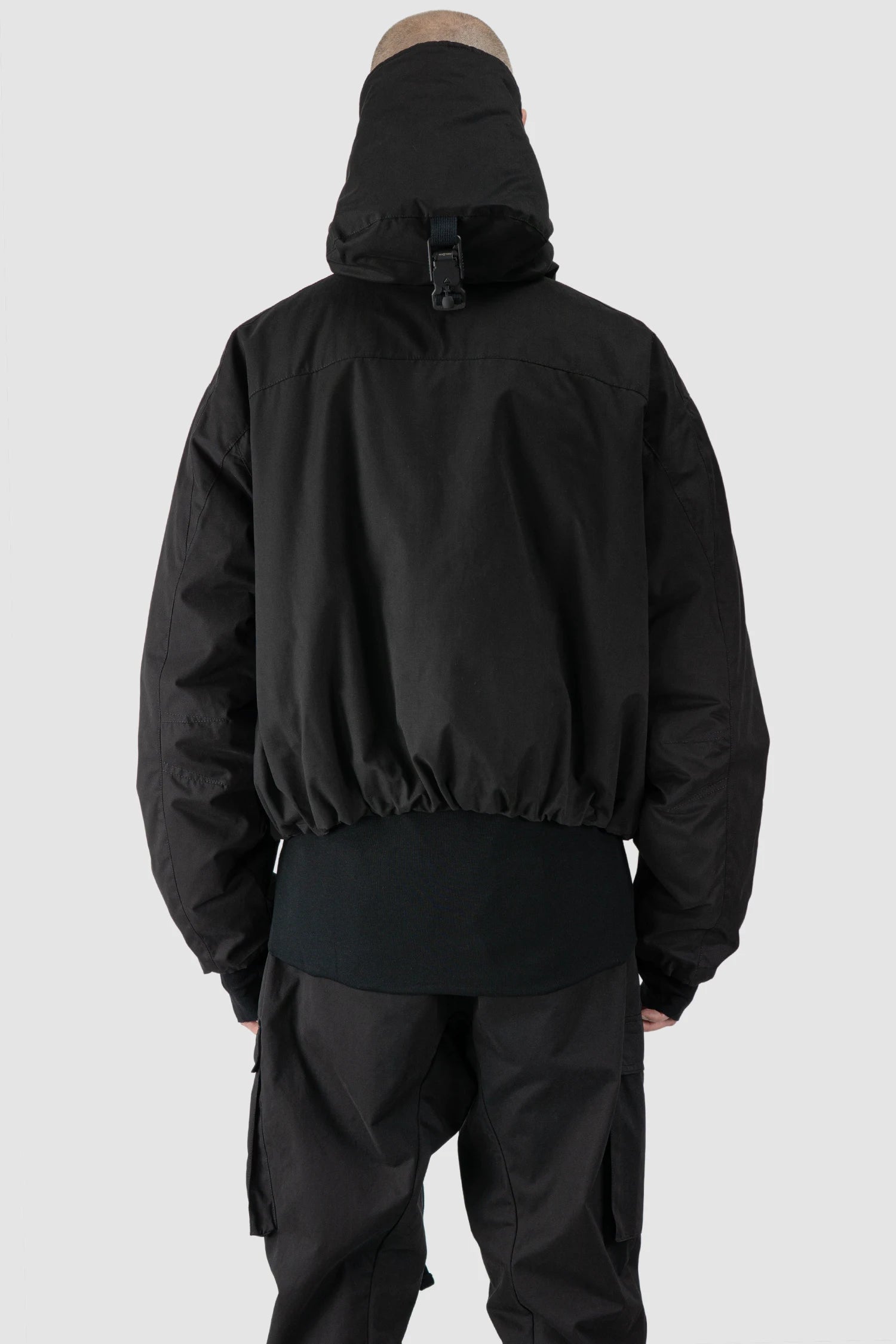 Thom Krom - model back view of men’s Black Padded Short Jacket with Magnetic Buckle Hoody M-J-74