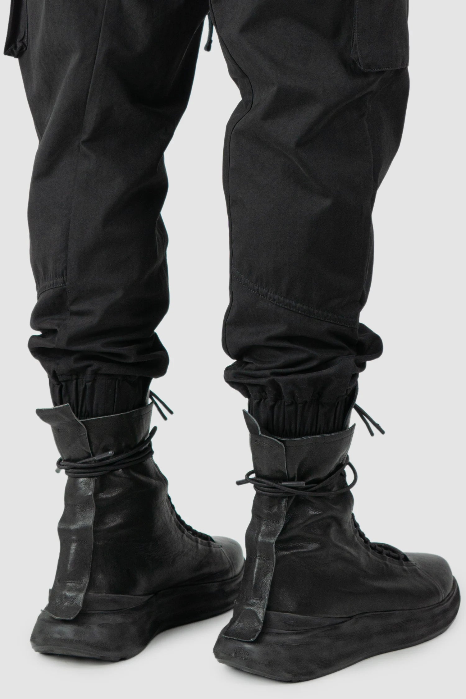 Thom Krom - model cuff detail view of men’s FW25 Black Peached Cotton Cargo Trousers with Magnetic Belt - M-P-15