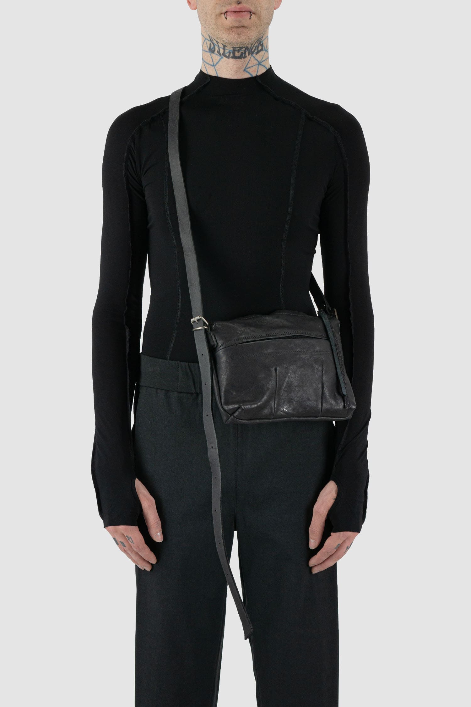0.Hide - Model view of black leather Essential Messenger Bag.