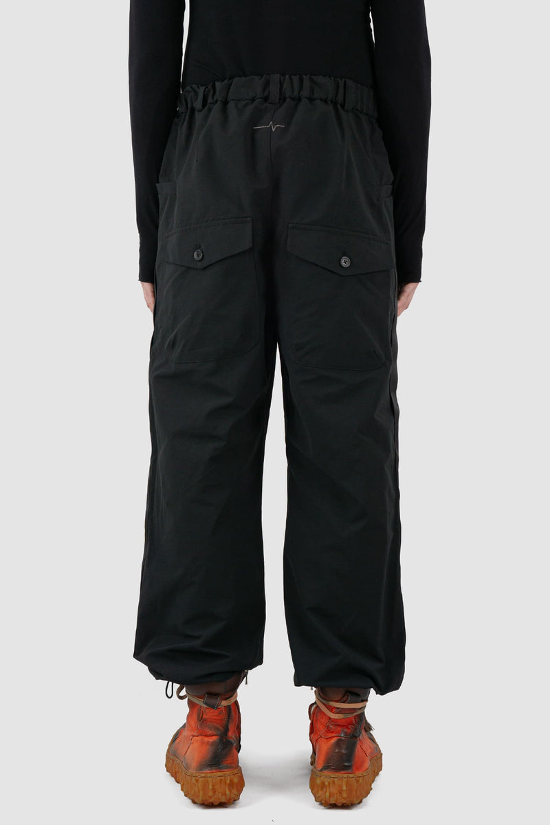 First Aid to the Injured - back view of black belted utility pants with side straps for men from the FW24 collection feature an integrated snap belt and an elasticated parachute hem fastening.