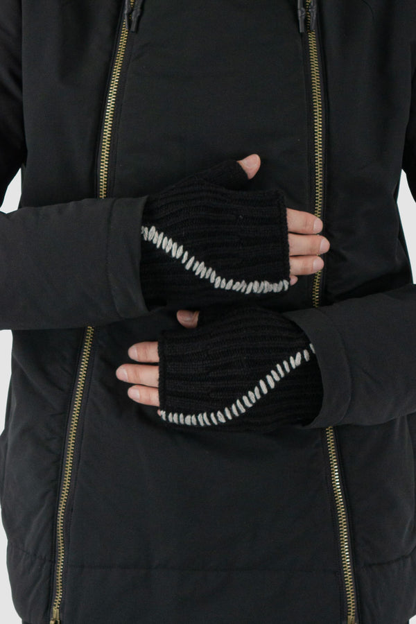 First Aid to the Injured - detail view of black knitted contrast stitch wool mittens.