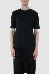 First Aid to the Injured - front view of black cotton T-Shirt with asymmetrical stitching for men from the FW24 collection with decorative flatlock seams on the body and shoulders.