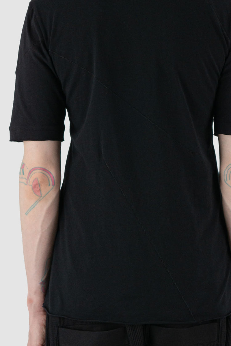 First Aid to the Injured - arm detail view of black cotton T-Shirt with asymmetrical stitching for men from the FW24 collection with decorative flatlock seams on the body and shoulders.