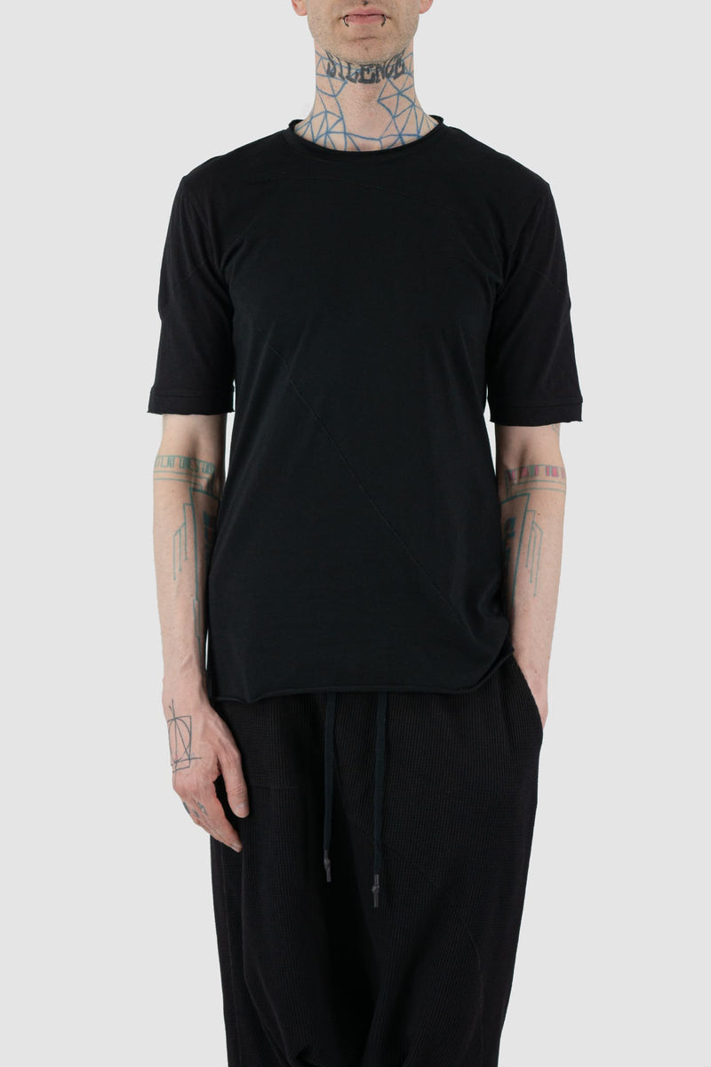 First Aid to the Injured - front relax view of black cotton T-Shirt with asymmetrical stitching for men from the FW24 collection with decorative flatlock seams on the body and shoulders.