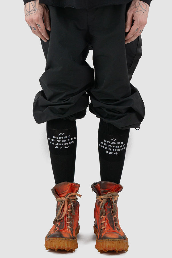 First Aid to the Injured - front view of black "Crash against the shore" logo socks.