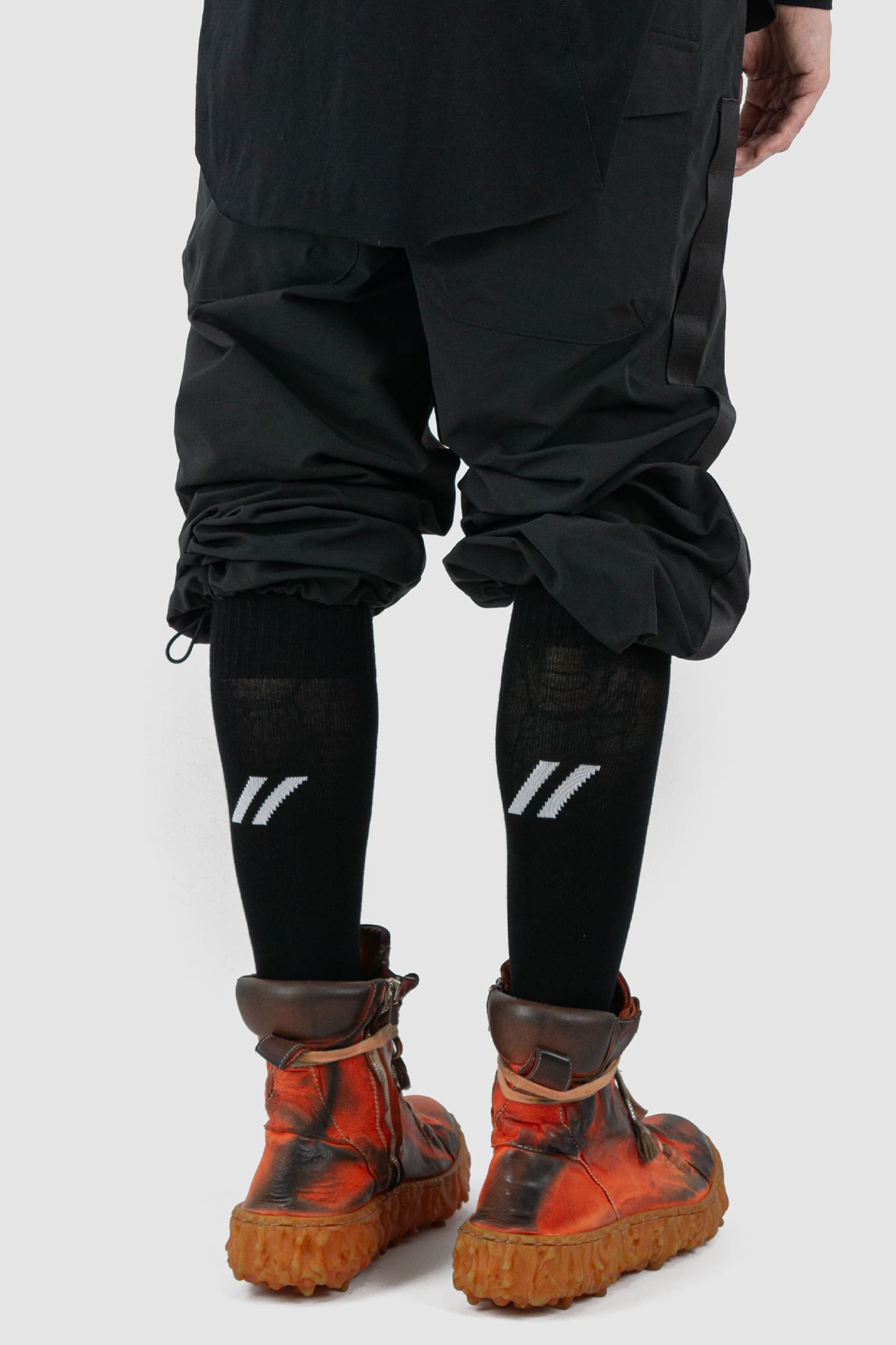 First Aid to the Injured - back view of black "Crash against the shore" logo socks from the FW24 collection with contrasted branding and knee-high design.