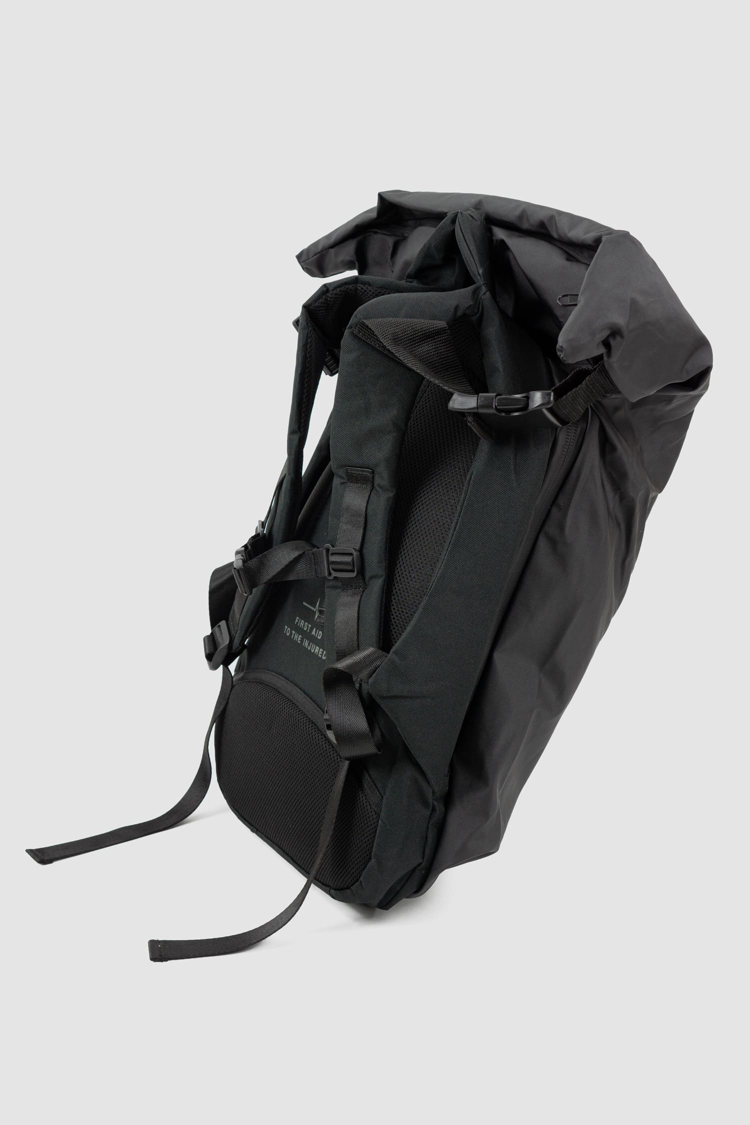 First Aid to the Injured - solo left view of black "Crash against the shore" utility backpack from the permanent collection with hidden cape and roll-top closure and zipper.