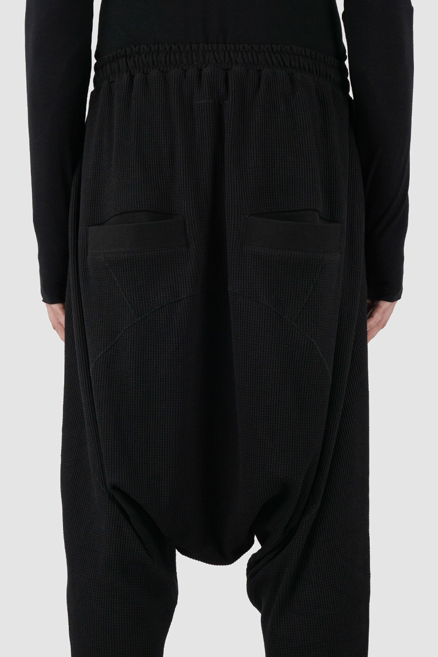 First Aid to the Injured - back detail view of black drop crotch waffle cotton joggers for men from the FW24 collection with elastic waistband and drawstring as well as 2 back and 2 side pockets.
