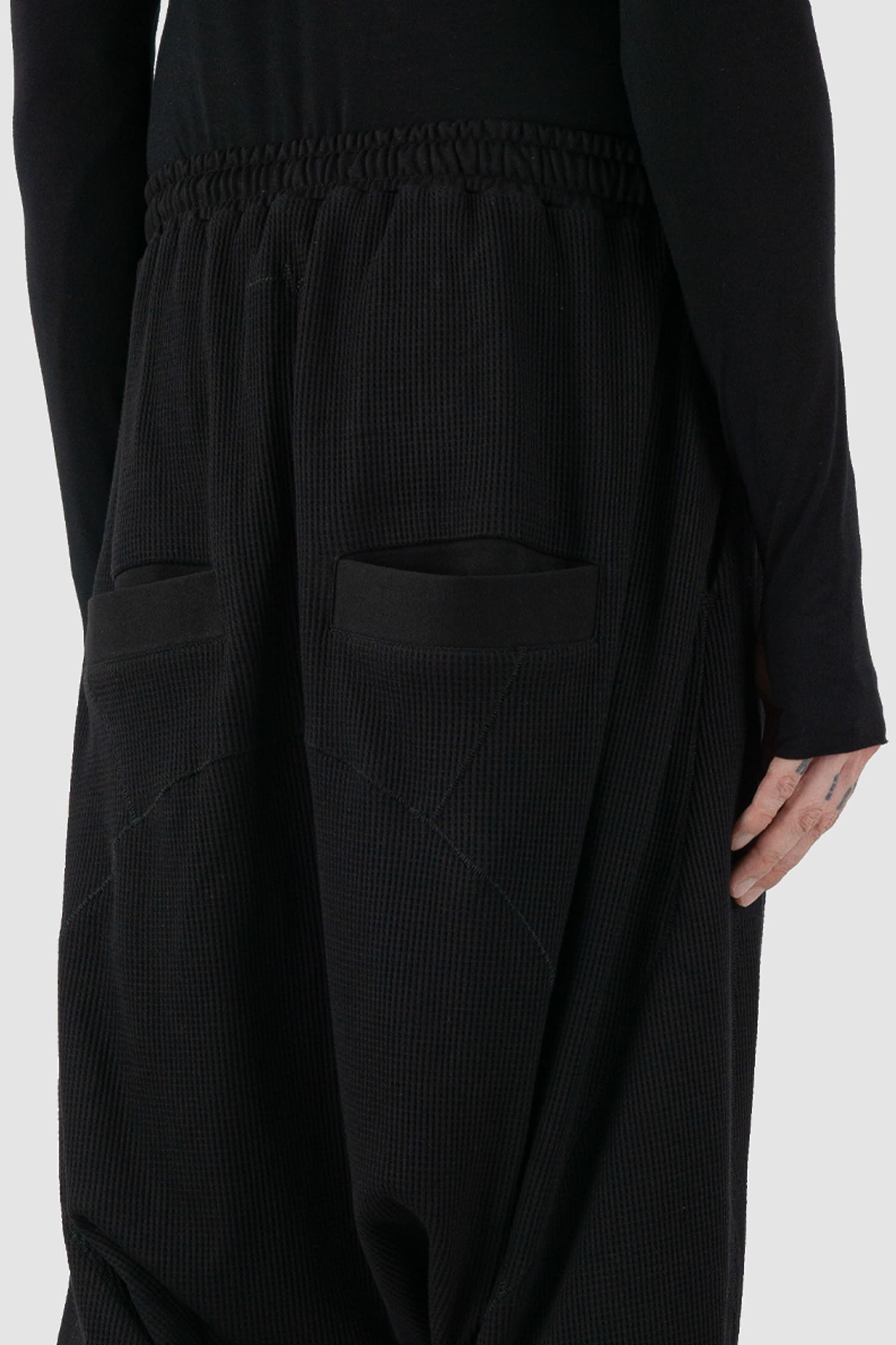 First Aid to the Injured - back side detail view of black drop crotch waffle cotton joggers for men from the FW24 collection with elastic waistband and drawstring as well as 2 back and 2 side pockets.