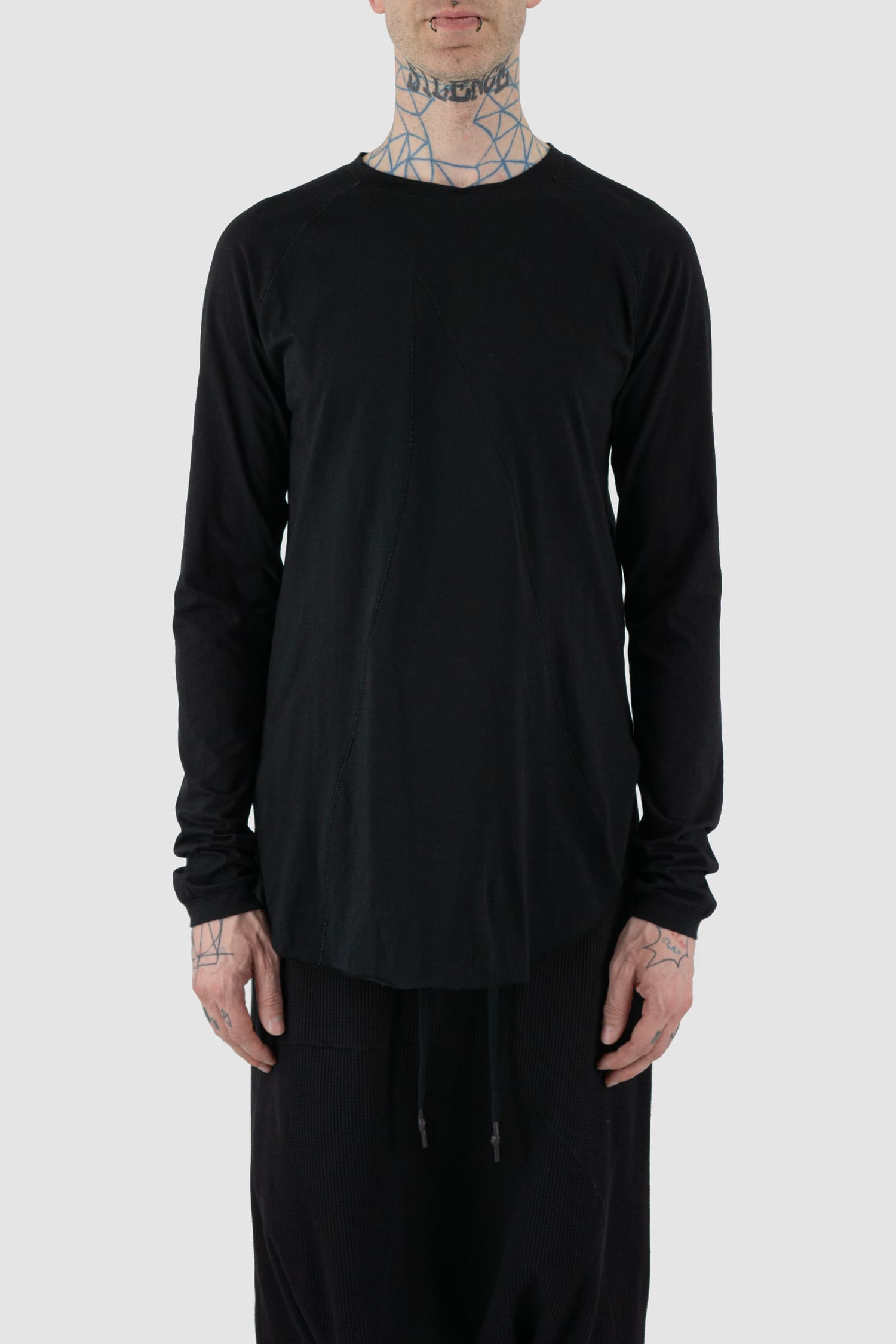 First Aid to the Injured - front view of black long sleeve T-Shirt with rounded hem for men from the FW24 collection with long back, side slit and decorative flatlock seams.