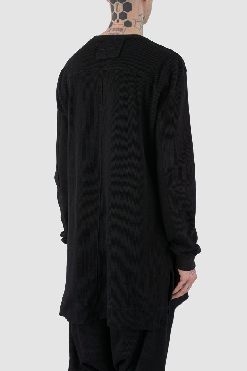 First Aid to the Injured - back side view of black long waffle textured cotton jersey sweater for men from the FW24 collection. Featured a kangaroo pocket, contrasting arm panels and side slits.