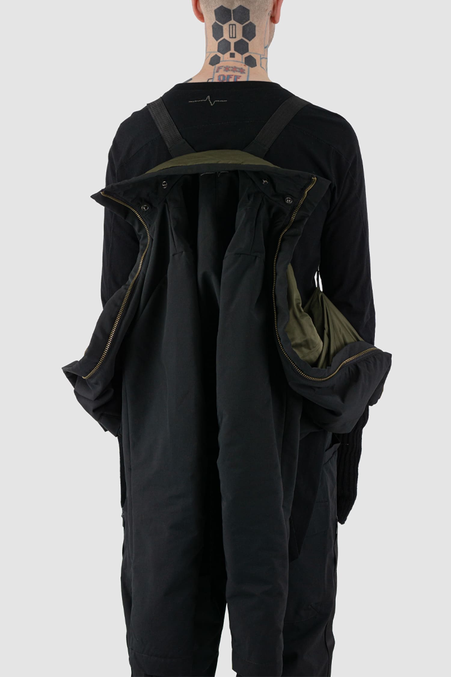 First Aid to the Injured - back carry  view of black padded jacket with double zipper closure for men from the FW24 collection with detachable hood, 2 long zippers to close the jacket and knitted-in cuffs with thumb holes.