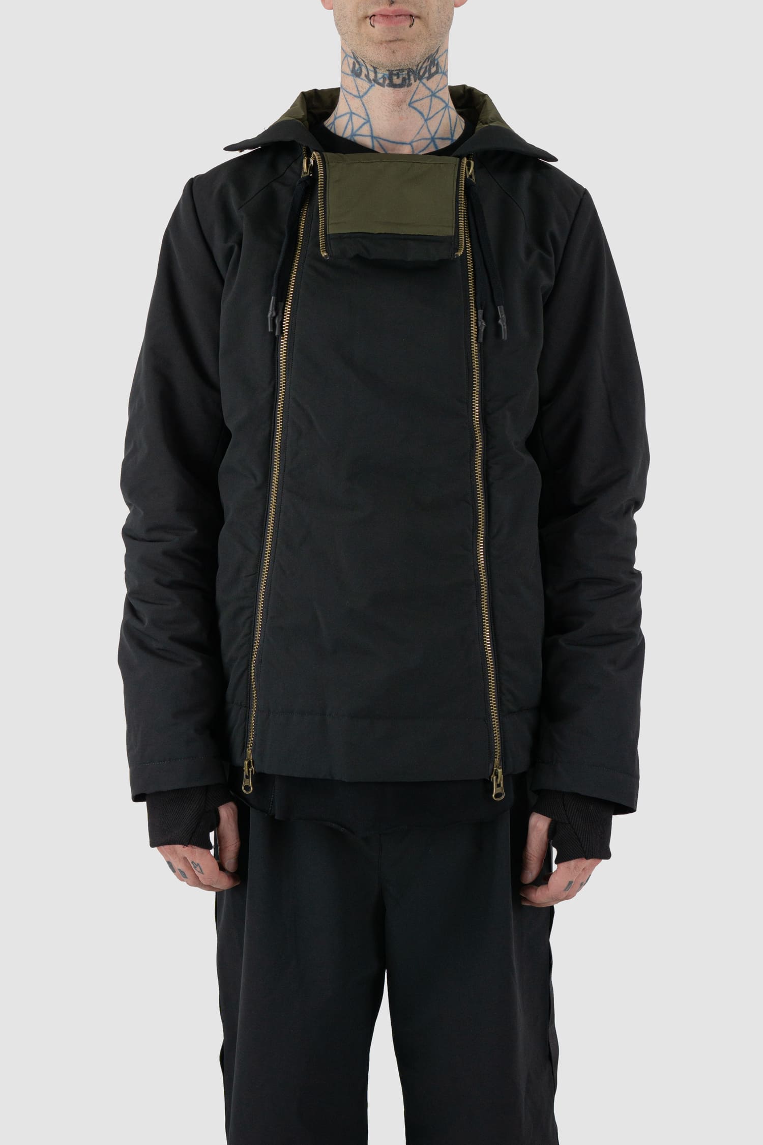 First Aid to the Injured - front open view of black padded jacket with double zipper closure for men from the FW24 collection with detachable hood, 2 long zippers to close the jacket and knitted-in cuffs with thumb holes.