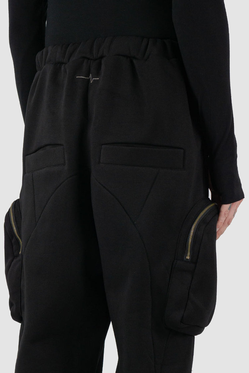 First Aid to the Injured - logo view of black tactical cargo joggers with side zip pockets for men from the FW24 collection with semi low crotch design, American fleece and spacious zipper pockets.