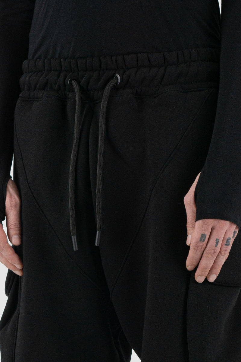 La Haine Inside Us - Front detail view of black men's heavy cotton baggy cargo sweatpants with high hem at the ankle, adjustable waistband, FW24 collection.