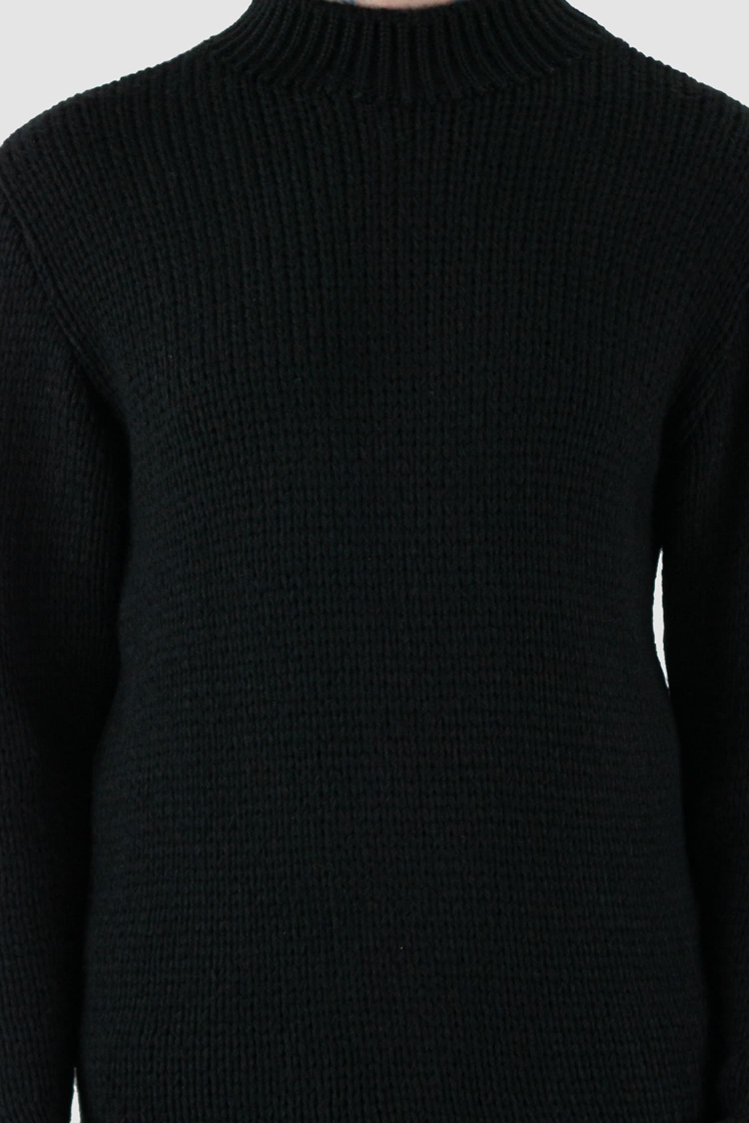 La Haine Inside Us - front detail view of black wool blend knit sweater for men from the FW24 collection with a thicker neck, hem- and cuffs and a straight fit.