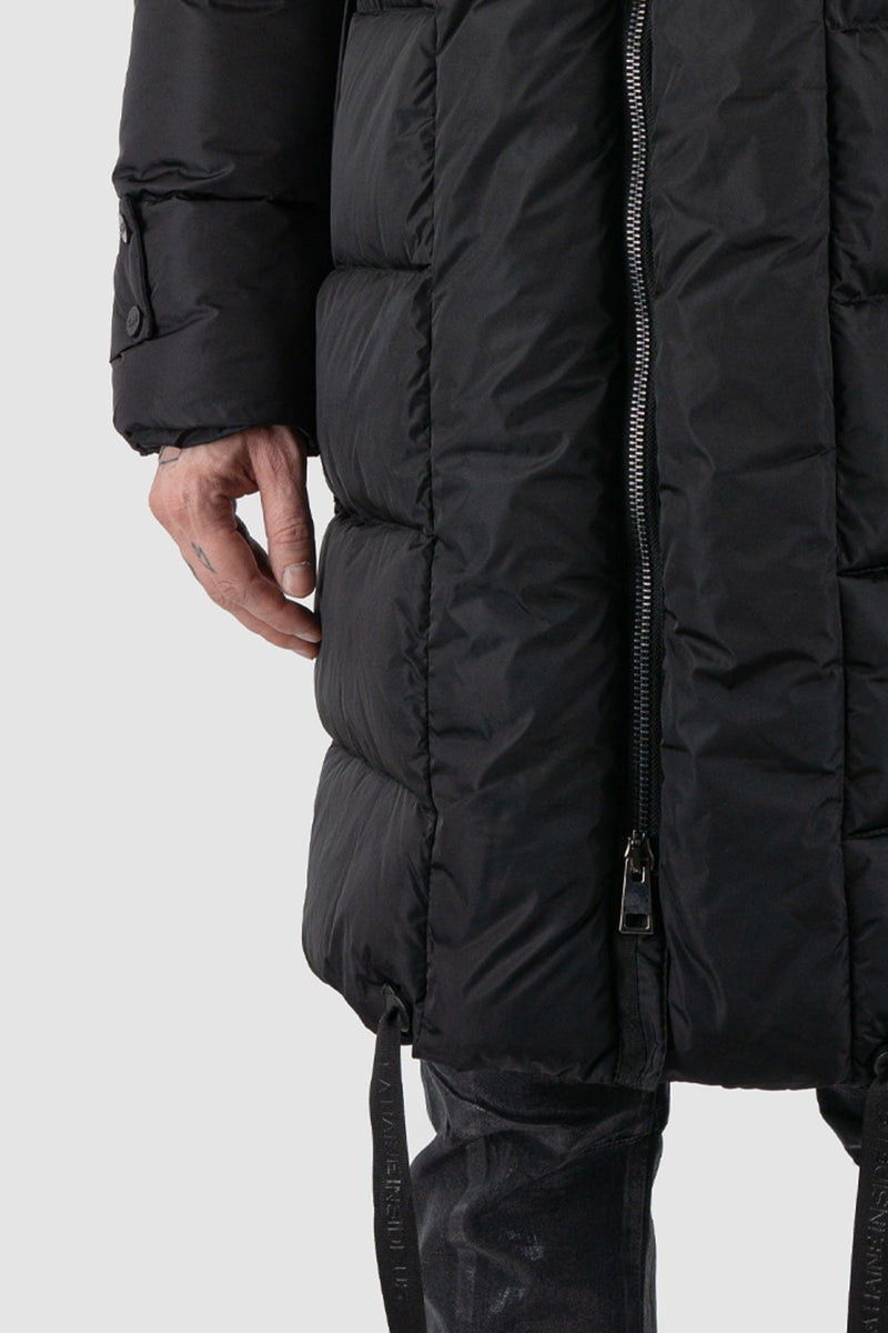 La Haine Inside Us - Front hem view of black men's long padded puffer coat with detachable hood, zippered pockets, two-way zipper, FW24 collection.