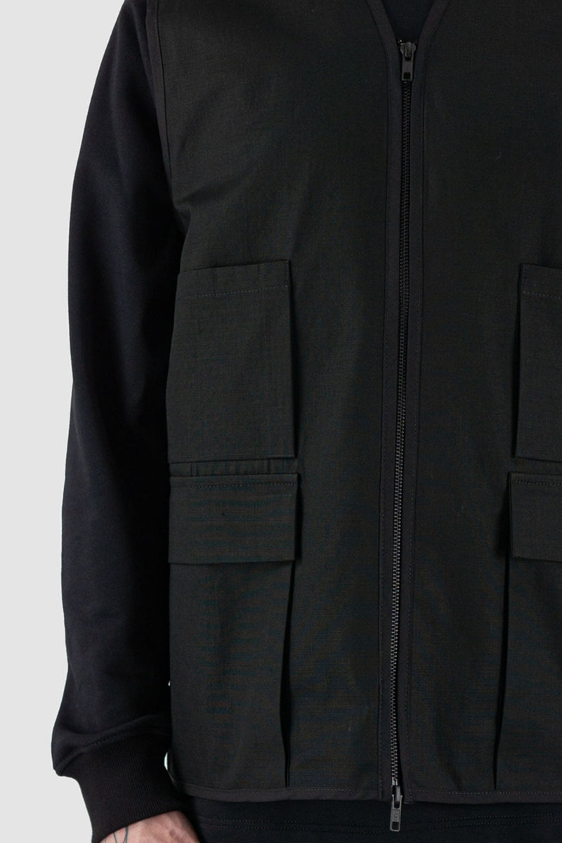 Nomen Nescio - Front detail view of black cotton field vest with multiple pockets, zip fastening, loose fit.