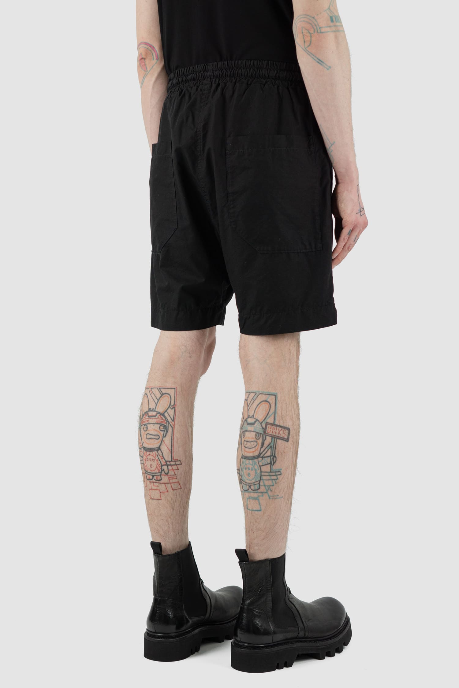 Nomen Nescio - back side view of black light field shorts with elastic waistband, slanted side pockets.
