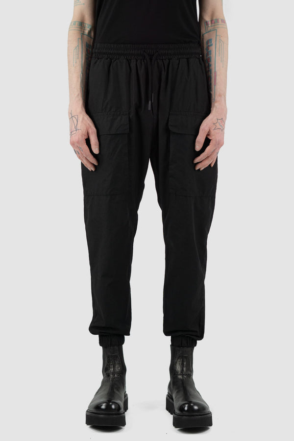 Nomen Nescio - Front view of black light pocket pants with elastic waistband, patched front pockets.