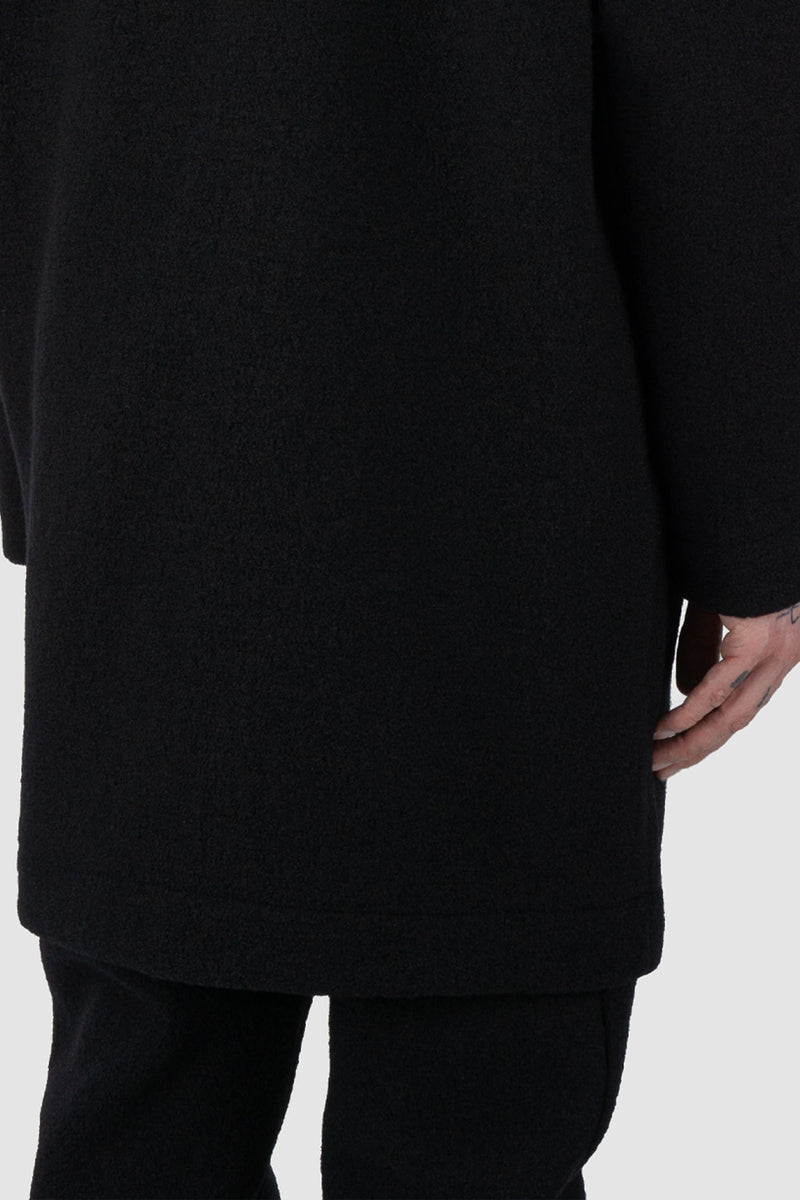 Nomen Nescio - back hem view of black long wool sweater 520 for men from the FW24 collection features a relaxed, oversized fit with raglan shoulders for a contemporary look.