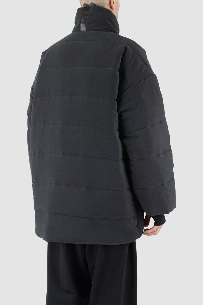 UY Studio - back side view of black big puffer coat with big patch stitched pockets.