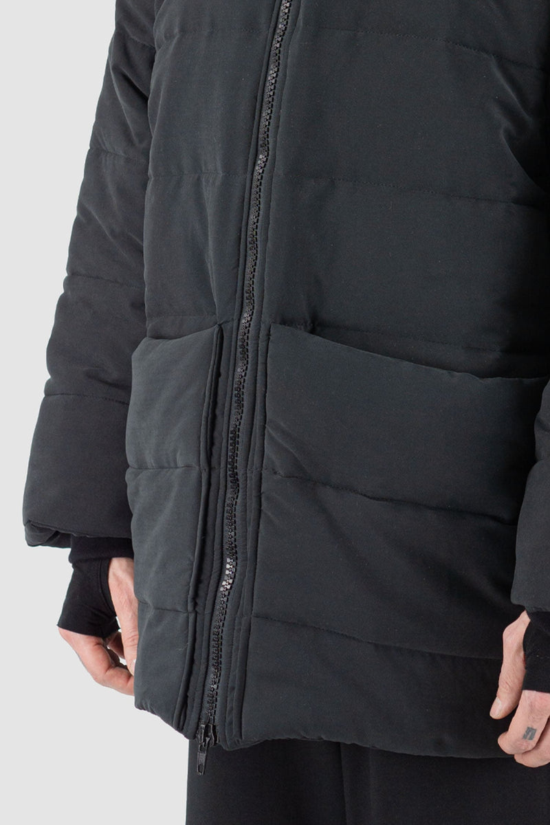 UY Studio - pocket detail view of black big puffer coat with big patch stitched pockets.