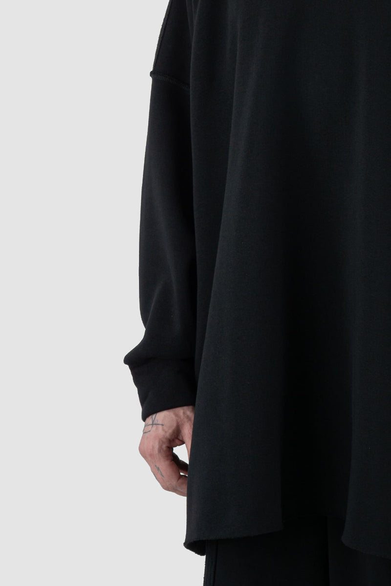 UY Studio - front arm view of big black cozy oversized cotton sweater for men from the FW24 collection offers a relaxed, baggy fit with a round neckline and stylish pleated sleeves.